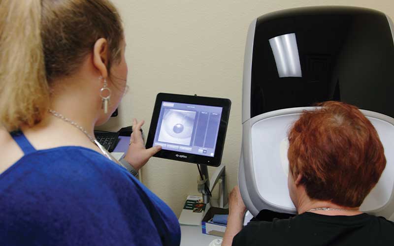 Charity showing a patient their eye scan.